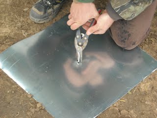 Cutting Out the Drilled Center Hole in the Flashing for the Concrete Pier Homemade Termite Shield