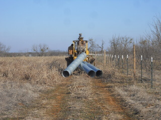 Dragging Culvert Pipe with Backhoe